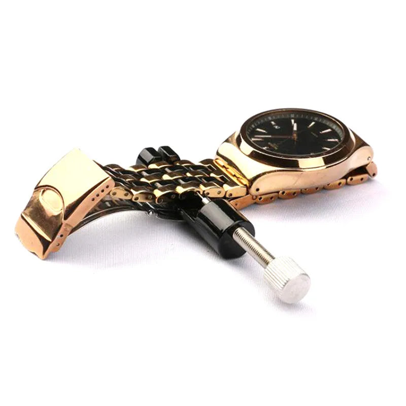 A precision metal watch strap adjuster tool with a gold-toned watch and black adjustment mechanism.