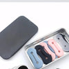 Una bandeja plateada contiene varias hebillas ajustables para extensiones de mangas de camisa en varios colores como negro, r