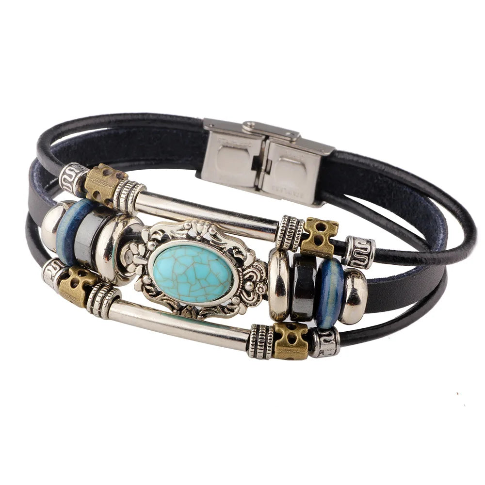 A black leather bracelet featuring a silver compass design with blue and turquoise stones.