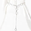 A delicate silver diamond heart chain waist belt displayed against a white fabric background.