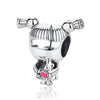 A silver family tree charm jewelry piece featuring a stylized face and a small animal figure.
