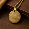 A gold-colored pendant necklace featuring the Ayatul Kursi verse engraved on a circular disc.