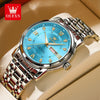 A stainless steel watch with a blue dial and gold accents is shown on a light background.
