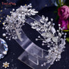 A delicate crystal bridal headband featuring intricate floral and vine designs on a clear stand.
