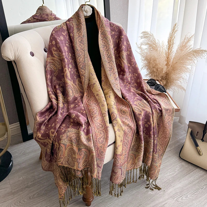 A richly colored bohemian paisley tassel shawl draped over a mannequin.
