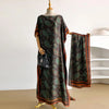 A woman wearing a dark patterned cape shawl over a dress, displayed on a mannequin.
