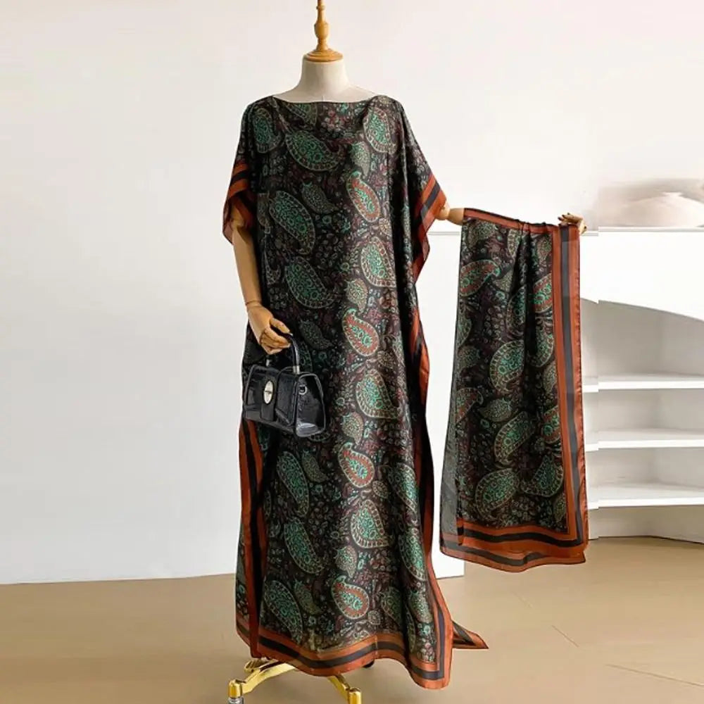 A woman wearing a dark patterned cape shawl over a dress, displayed on a mannequin.