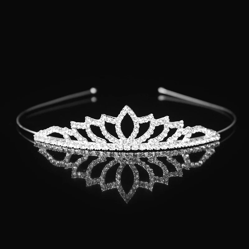 Tiara y corona de princesa de cristal brillante, accesorio para el cabello reflejado en una superficie negra.