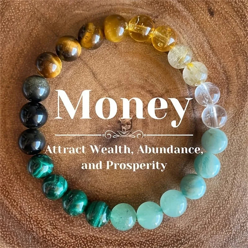 A bracelet made of natural stone beads in shades of amber, gold, and seafoam green, laid on a wooden surface.