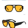 Vue de face de lunettes de soleil carrées vintage noir et jaune à double pont.