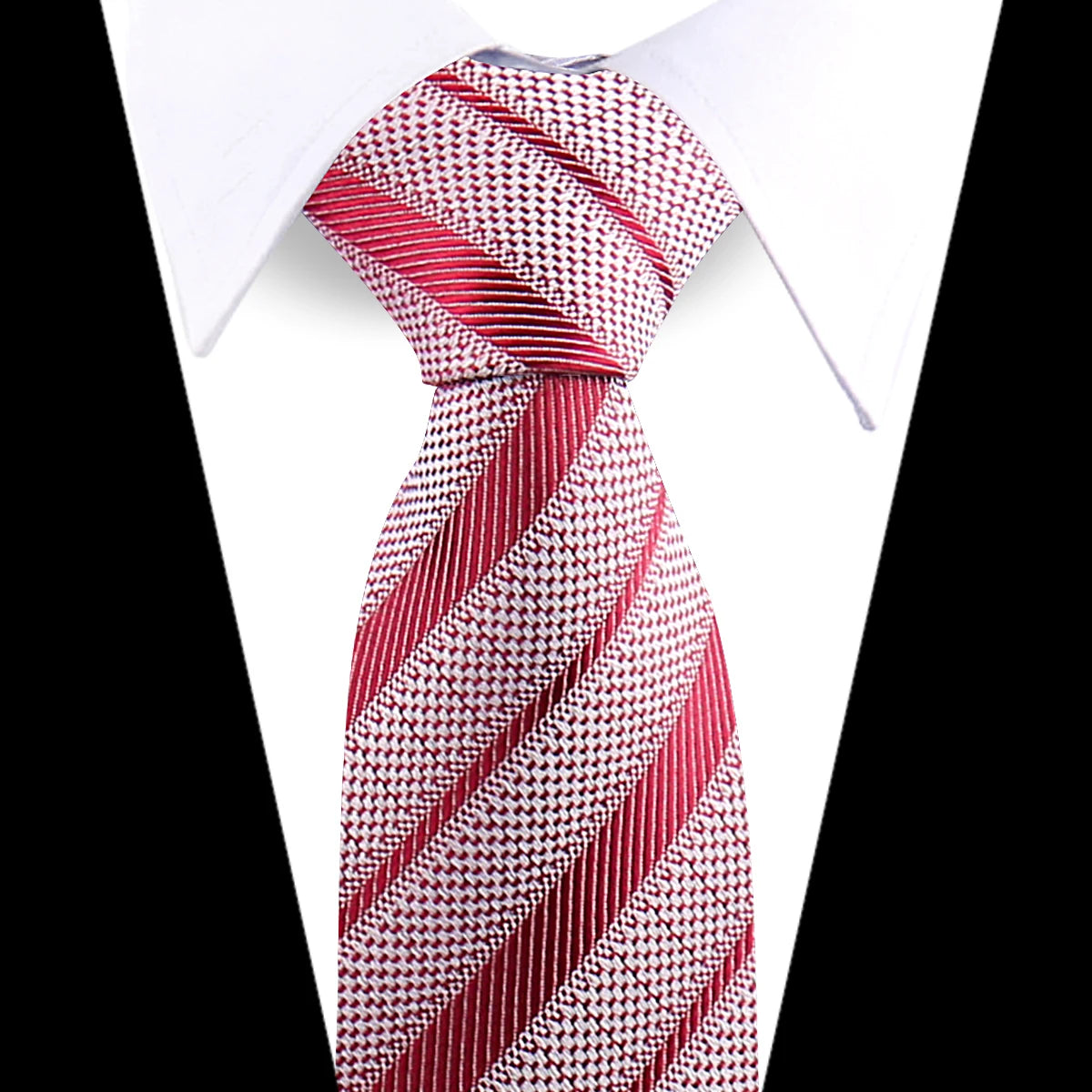 A close-up of an elegant red and white patterned silk necktie tied in a diagonal stripe pattern against a white shirt.