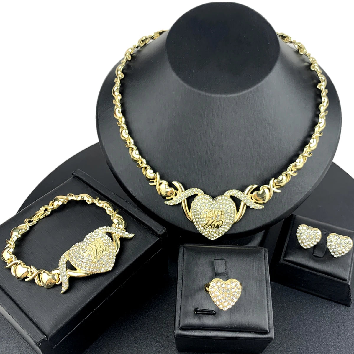 A gold heart crystal jewelry set featuring a necklace and bracelet displayed on a black stand.