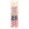 A collection of handmade ribbon bow hair clips in various pastel shades including yellow, pink, beige, and gray.