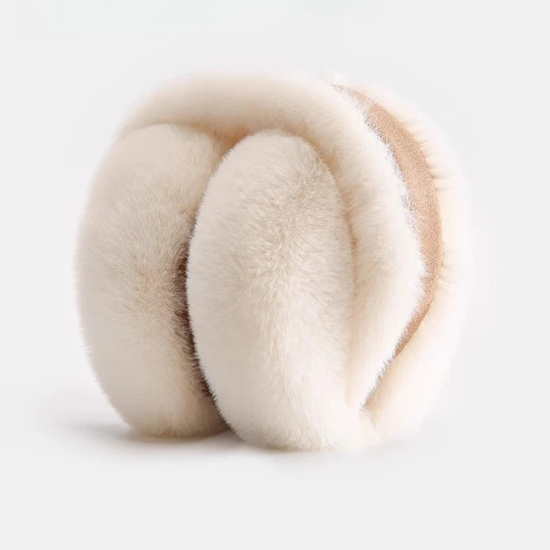 A close-up of classic winter ear muffs made of light beige faux fur.