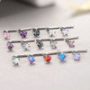 A collection of surgical stainless steel nose piercing studs featuring various colored gemstones like pink, purple, blue, and
