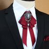 A black suit jacket with a white shirt and a deep red rhinestone bow tie neck tie