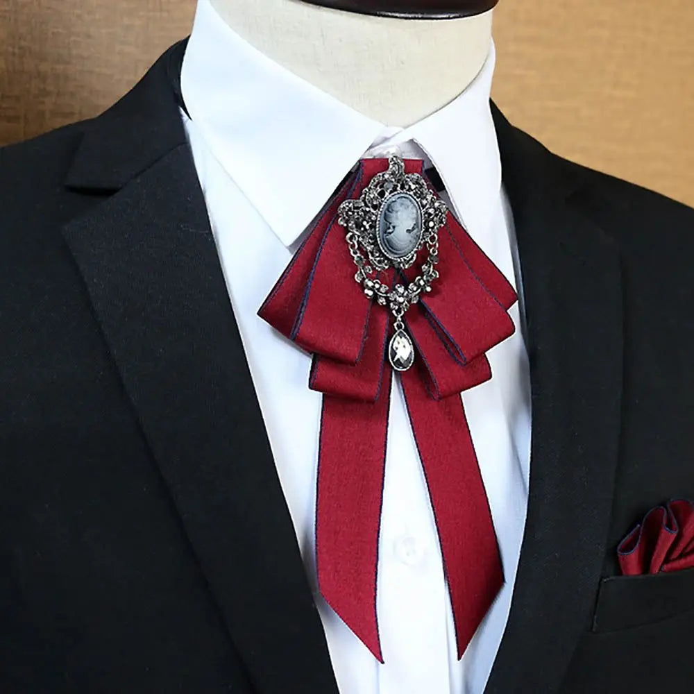 A black suit jacket with a white shirt and a deep red rhinestone bow tie neck tie