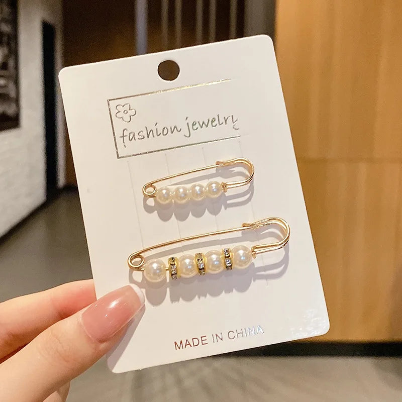 Gold-toned pearl brooch pins displayed on a white card, ready for customization.