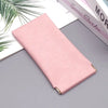 A pink premium PU leather eyewear storage bag lying on a gray surface next to some books.