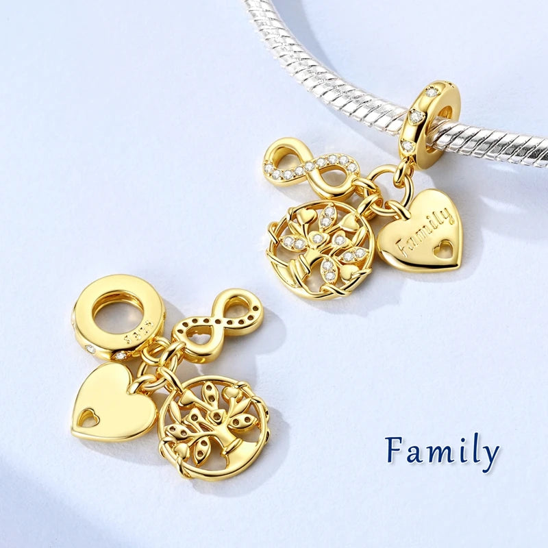 Gold-tone charm bracelet featuring a heart and tree pendant on a silver chain.