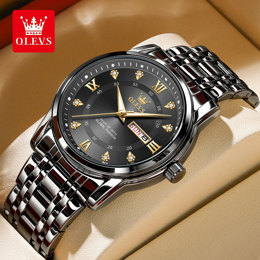 A close-up shot of a stainless steel watch with a black dial and gold accents on a beige background.