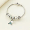 A silver bracelet featuring various beads including clear stones, iridescent accents, and a pearl drop.