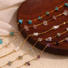 Gold plated foot chains featuring various crushed stone beads in shades of blue, pink, and purple