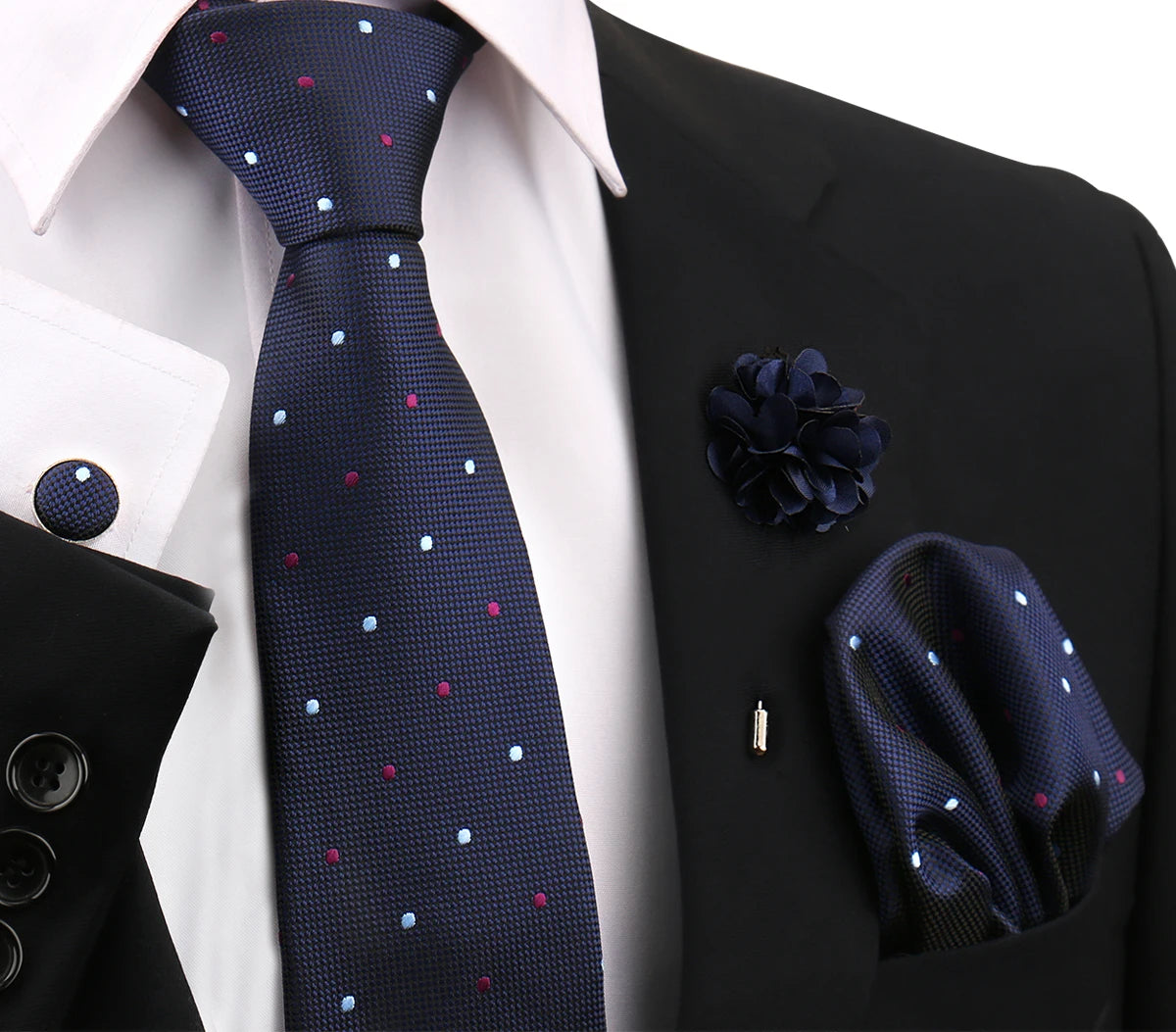 Dunkelblaue gemusterte Krawatte und Accessoires vor weißem Hemd und schwarzem Sakko.
