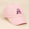 A pink baseball cap featuring a purple and iridescent rainbow unicorn embroidered on the front.