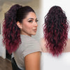 Gros plan d'une femme avec de longues extensions de cheveux bouclés et volumineux, rouge foncé