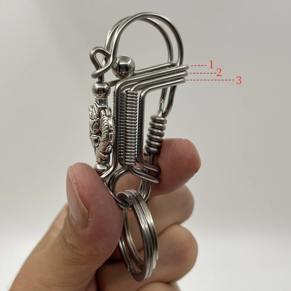 Un porte-clés mécanique en acier inoxydable avec anneau et barre texturée tenu dans une main.