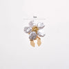 A small floral button cufflink featuring white pearl-like flowers and gold accents.