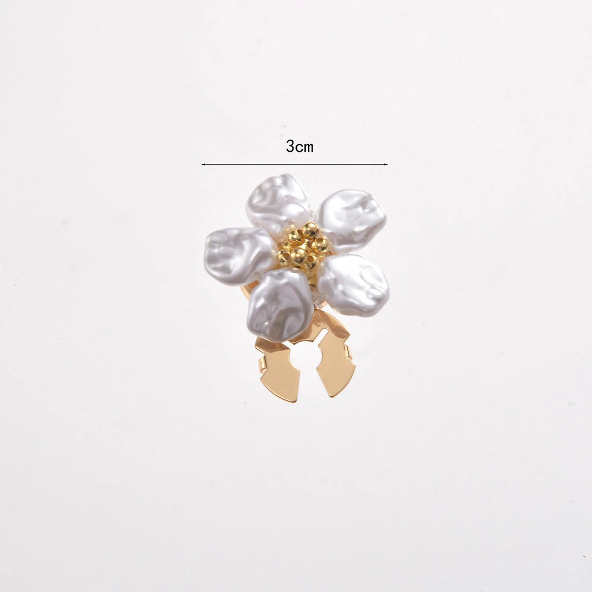 A small floral button cufflink featuring white pearl-like flowers and gold accents.