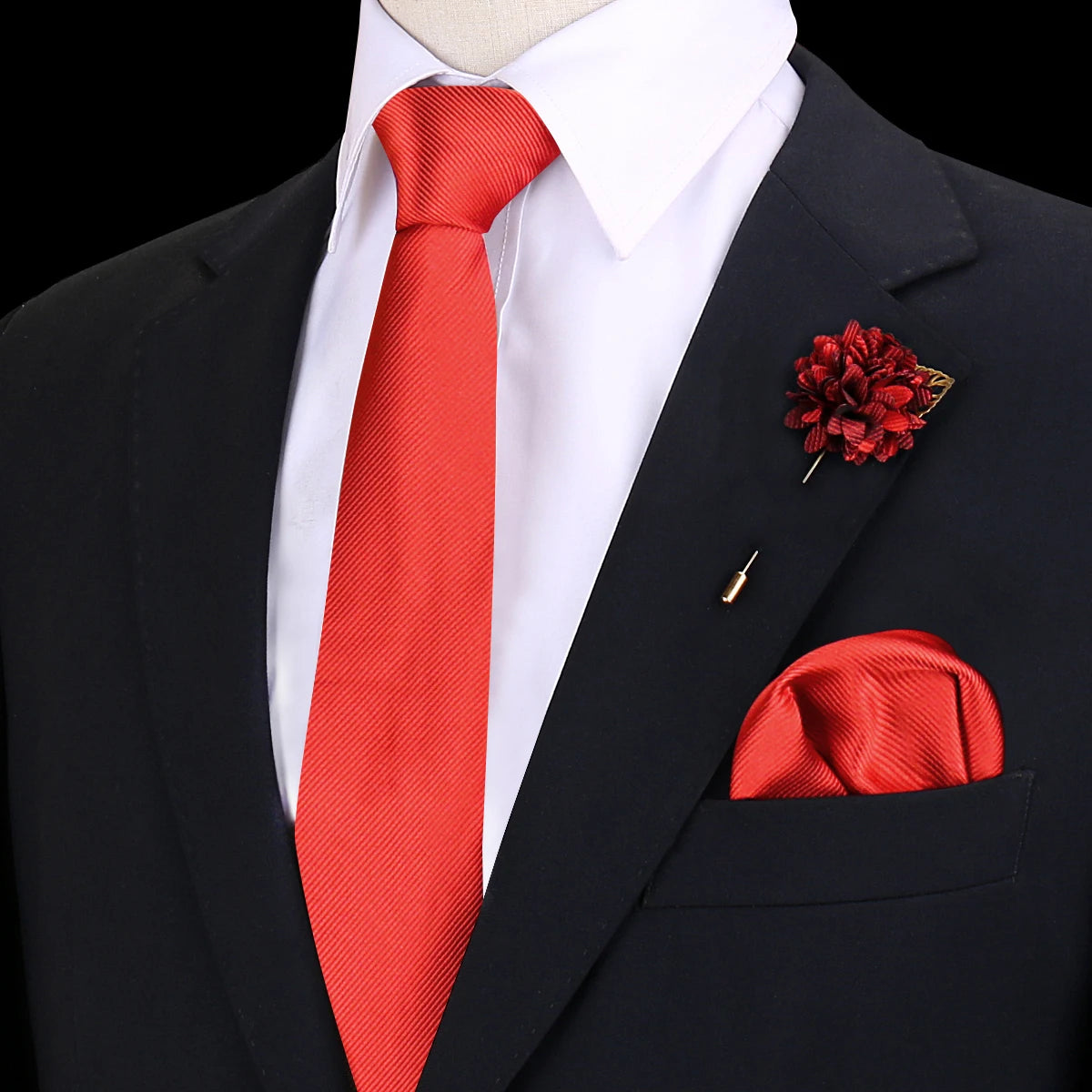 Chaqueta negra con camisa blanca, corbata de seda roja y una flor floral roja en la solapa.