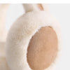 Close-up of classic winter ear muffs with soft white fur and tan padding.