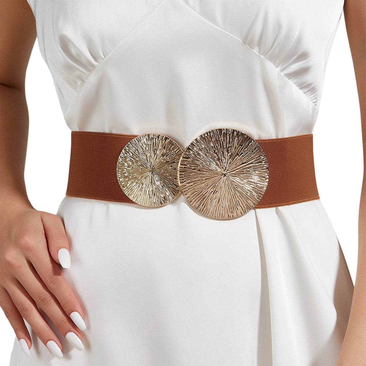 A close-up of a beige elastic waist belt with two round metallic gold embellishments worn on a white dress.