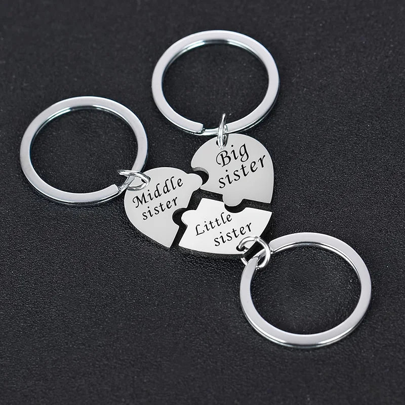 Silver keychain set featuring puzzle heart charms labeled Middle, Big, and Little sister
