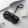 Black PU leather eyewear pouch and glasses case with a black strap resting on a white surface.