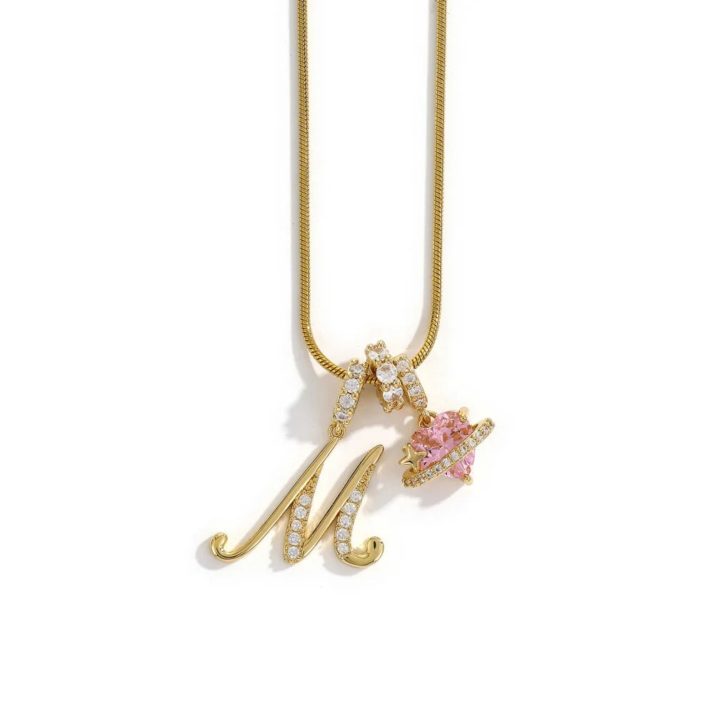 Gold chain necklace featuring an initial M pendant with pink gemstone accents.