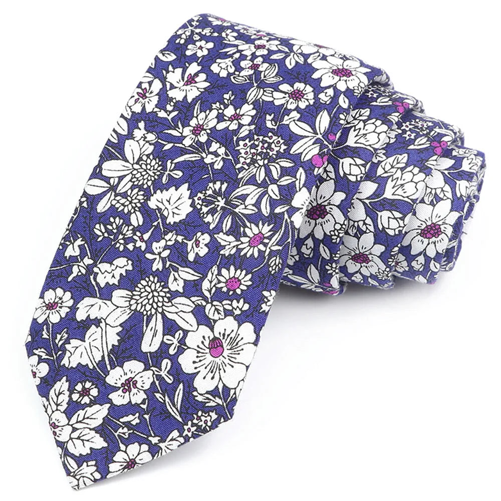 Gros plan d'une cravate en coton à imprimé floral élégante avec des fleurs blanches et violettes sur fond bleu foncé.
