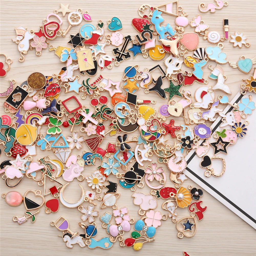 Collection de perles et charms en émail mélangés pour la création de bijoux, exposés sur une surface en bois clair.