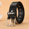 Black leather belt with silver rivets and buckle displayed on a beige background.