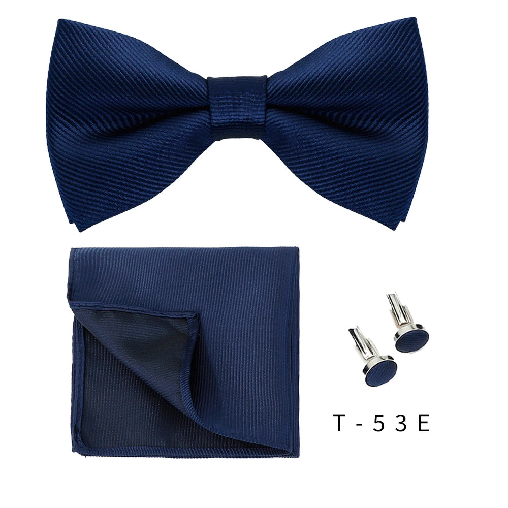 Navy blue bow tie and cufflinks set displayed on a white background.