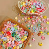 A collection of colorful decorative elastic hair bands and accessories in various pastel shades are displayed in woven basket