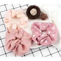A set of three pink and brown knitted hair scrunchies and headbands displayed on a white surface.