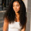 A woman with long, dark curly hair models a natural Jerry curl lace front wig.