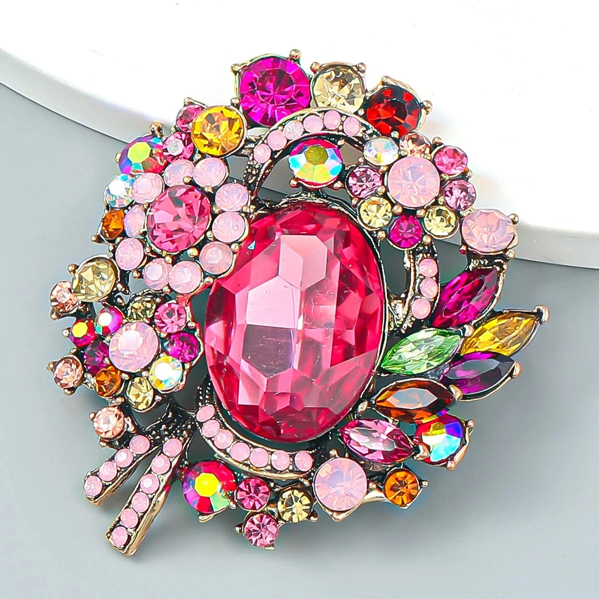 Broche fleur en cristal vibrante avec des pierres taillées rose, rouge et jaune.