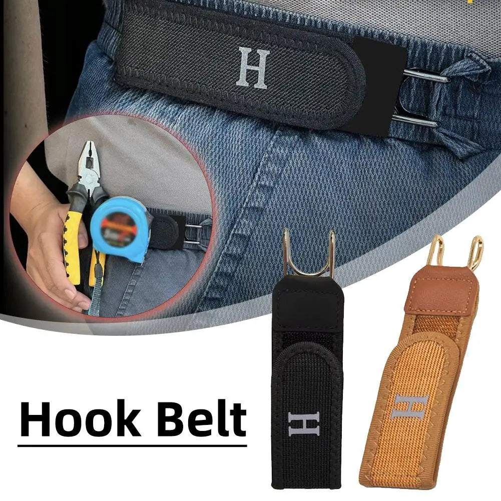 Cinturón con gancho negro y hebilla H plateada, junto a tela de mezclilla.