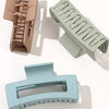 A set of seven square hair claw clips in various shades of beige and green, shown from different angles.
