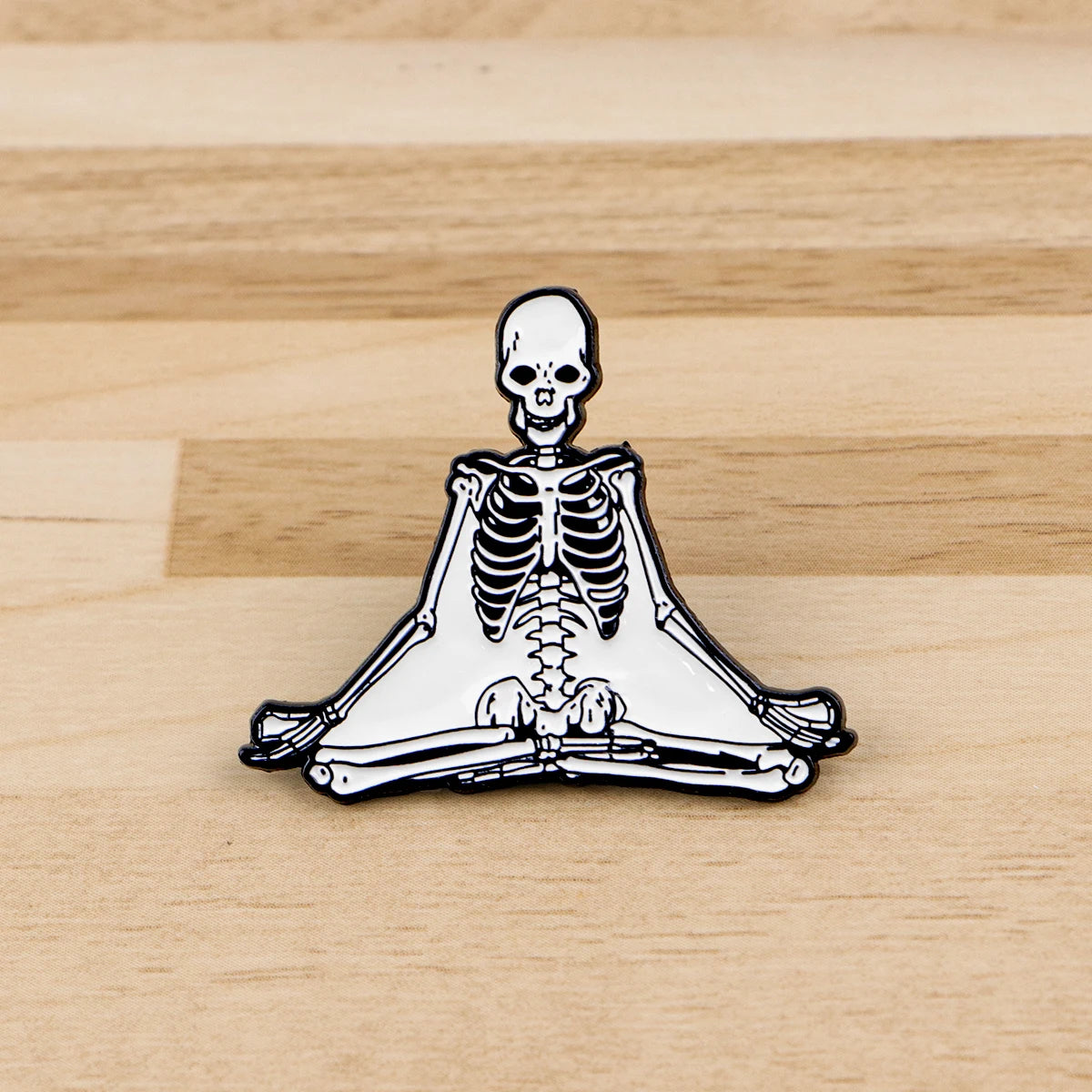 A set of enamel pins featuring a skeleton character design, including a skull and a full skeletal structure.